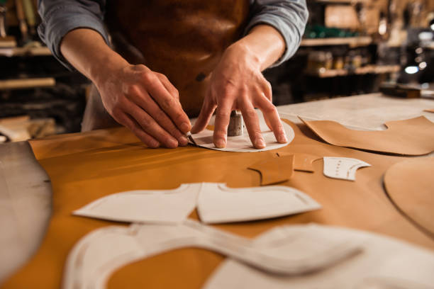 Craftsman cutting leather panels around a pattern