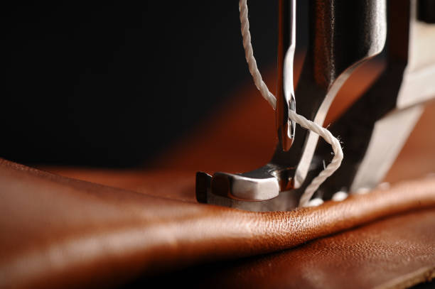 Sewing machine needle stitching a leather seam